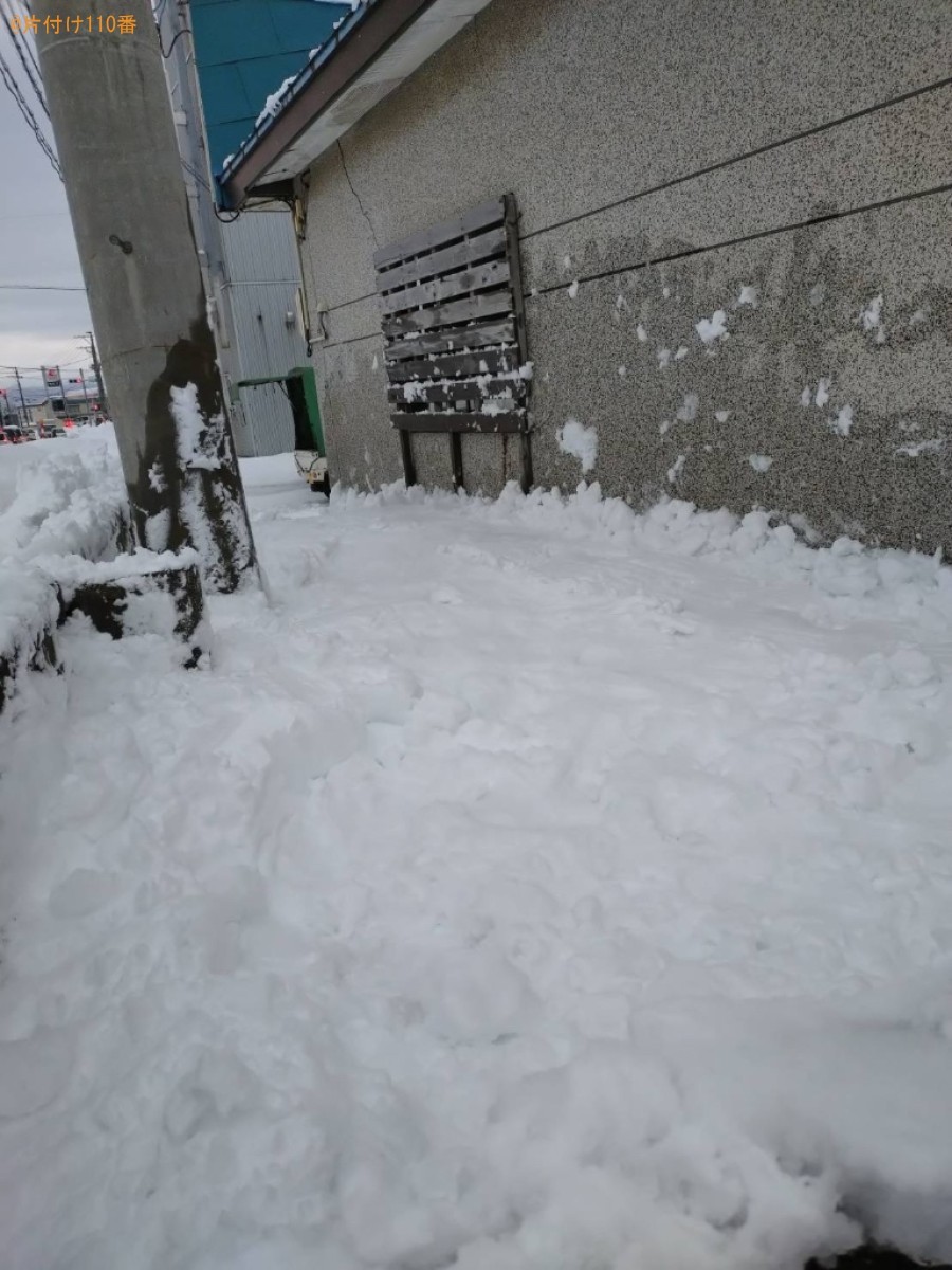 車庫の屋根の雪下ろし、屋根と塀の間に溜まっている雪の除雪作業